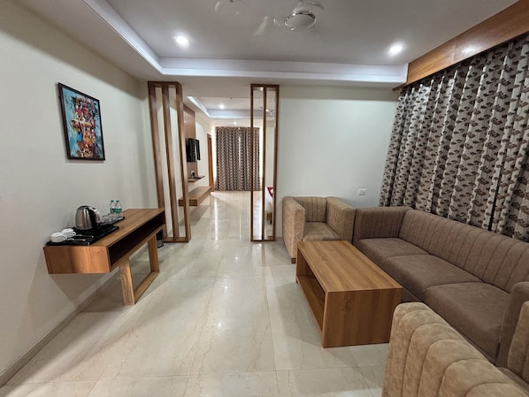 Una sala de estar moderna con un sofá, una mesa de centro y un televisor sobre un mueble de madera.