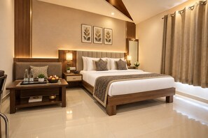 A modern hotel room with a large bed, bedside tables, a nightstand, a mirror, and a view of the outdoors. - The Elegance Resort (Chittorgarh)