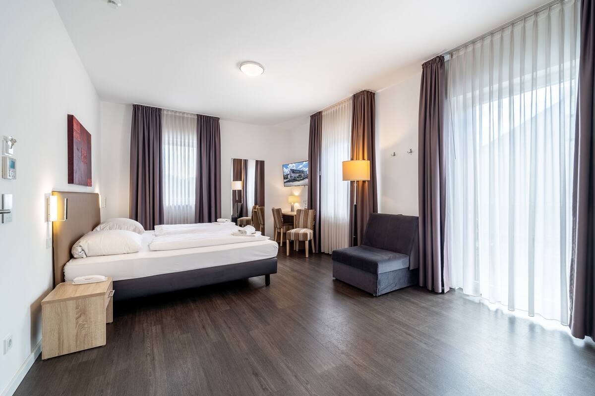 Een moderne hotelkamer met een groot bed, een bureau en een stoel.