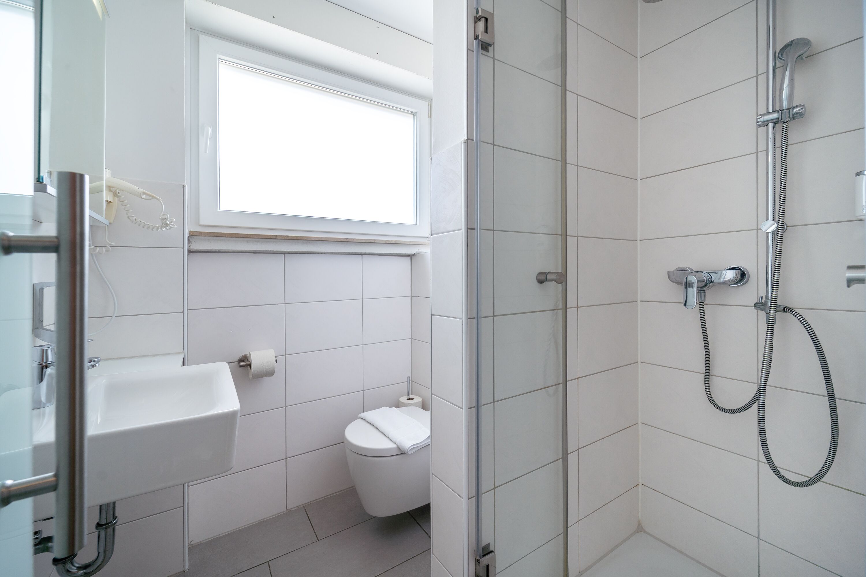 A bathroom with a toilet, sink, and shower.