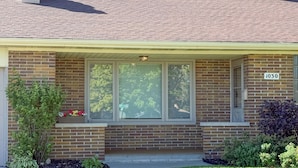 A two-story brick house with a covered front porch, a large window, and a mailbox. - The Huddle - Near Lambeau Field/Resch Center (Green Bay)