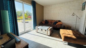 A modern living room with a sofa, a small table, a suitcase, and a lamp.