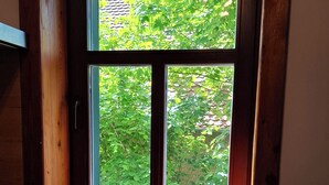 Una cuina amb finestra que dona a un jardí. Hi ha dues tasses blanques al davant de la finestra.