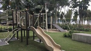 Un'area giochi con uno scivolo, strutture per arrampicarsi e una piccola collinetta.