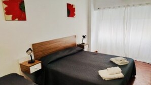 A bedroom with a bed, a bedside table, a lamp, and a window with curtains. - Gran monoambiente en centro de Bs As 1 C (Buenos Aires)