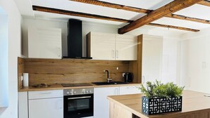 A modern kitchen with white cabinets, a wooden countertop, and a built-in oven. - Cozy Family Home near Ramstein Air Base – Comfort & Convenience (Hochspeyer)