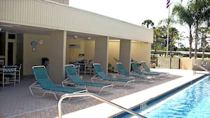 A poolside area with lounge chairs and a covered seating area. - Seasonal Rental: 1-bedroom condo, gated community, sunrises over Old Tampa Bay (Clearwater)