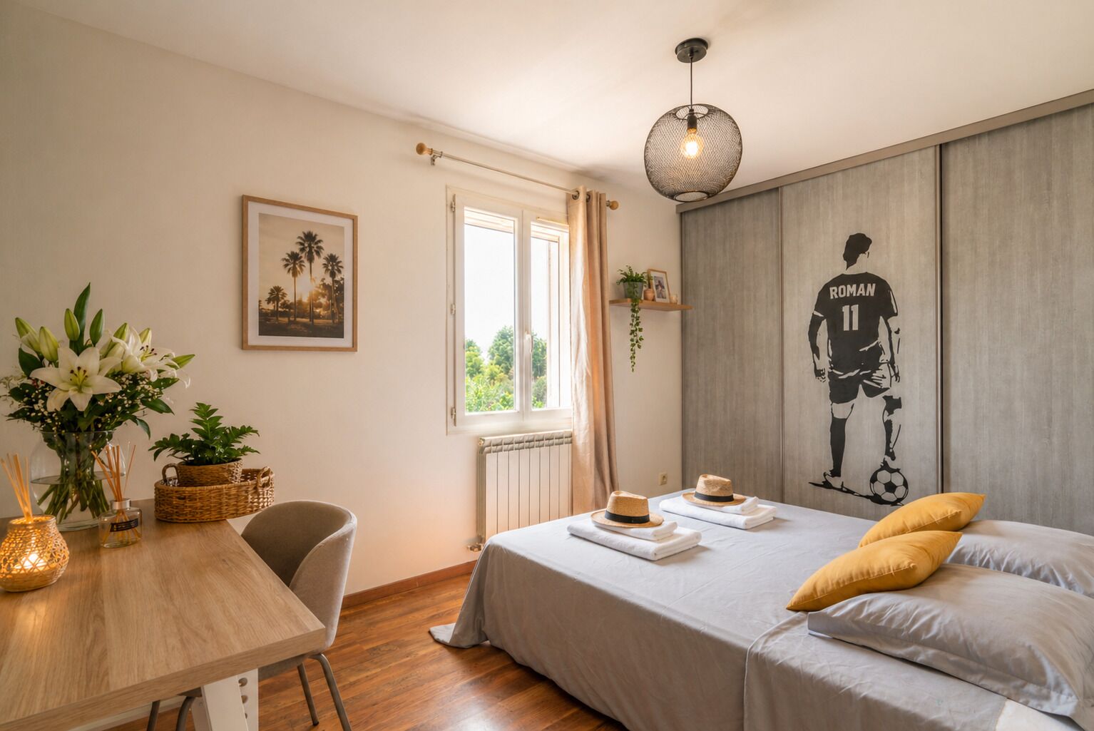 Ein Zimmer mit einem Bett, einem Tisch mit Blumen, einem Stuhl, einem Fenster und einer Wand mit einem Sportler.