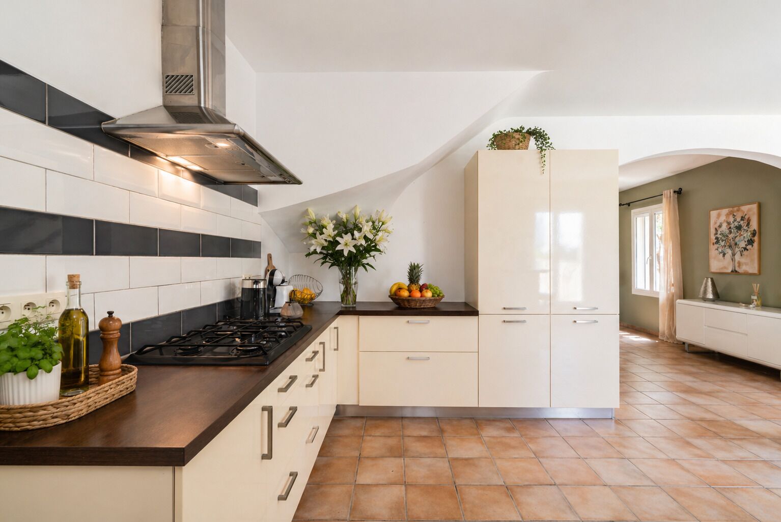 A kitchen with a stove, cabinets, and a fruit bowl.
