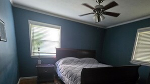 A bedroom with a bed, a ceiling fan, a nightstand, a lamp, and a window with blinds. -  A 3-bedroom house  in Georgetown, close to downtown, fully fenced back yard.  (Georgetown)