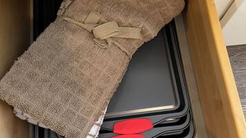 Een lade met een bruine handdoek, een zwarte dienblad en twee rode spatels.