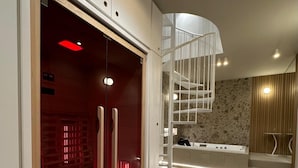 Een modern interieur met een kamer verlicht in rood, een witte spiraaltrap en een receptie.