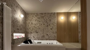 Een moderne badkamer met een vrijstaand bad, een wandmeubel en een grote spiegel.