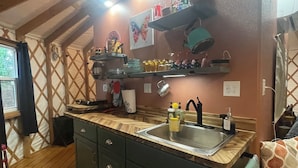 Une cuisine avec des meubles de rangement en bois, un évier à deux bacs et un meuble bahut au-dessus du plan de travail.