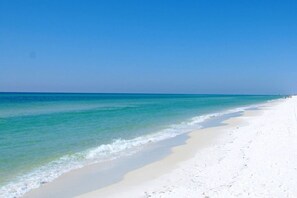 A beach with clear turquoise water and white sand.