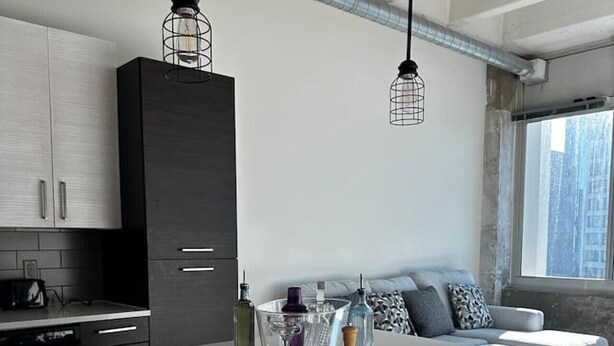 Een moderne keuken met een centraal eiland, barstoelen en een ingebouwde zithoek met kussens.