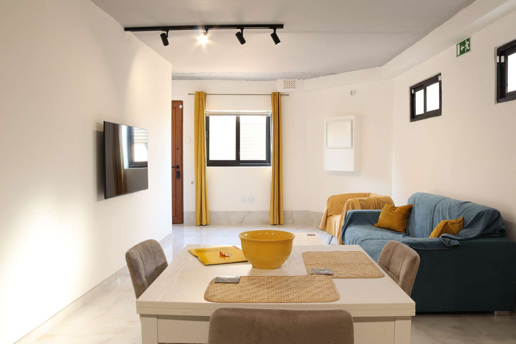 Un salon moderne avec une table à manger, un canapé et un téléviseur.