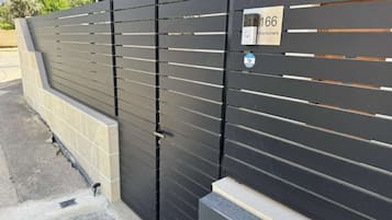 Un portail en métal noir, orné d’une plaque portant le numéro « 166 » et d’une enseigne indiquant le nom « Kantuniera ».
