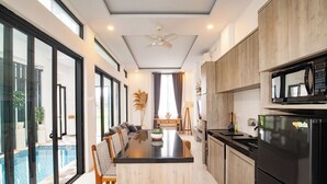 A modern kitchen with a central island, a built-in oven, and a microwave. - Triple Heaven Canggu (Canggu)