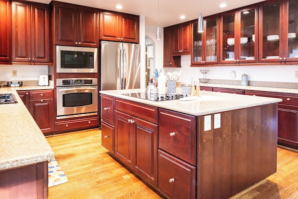 Una cocina moderna con armarios de madera, electrodomésticos de acero inoxidable y encimera de granito.