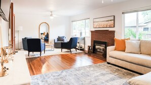 A living room with a fireplace, a sofa, a coffee table, and a mirror.