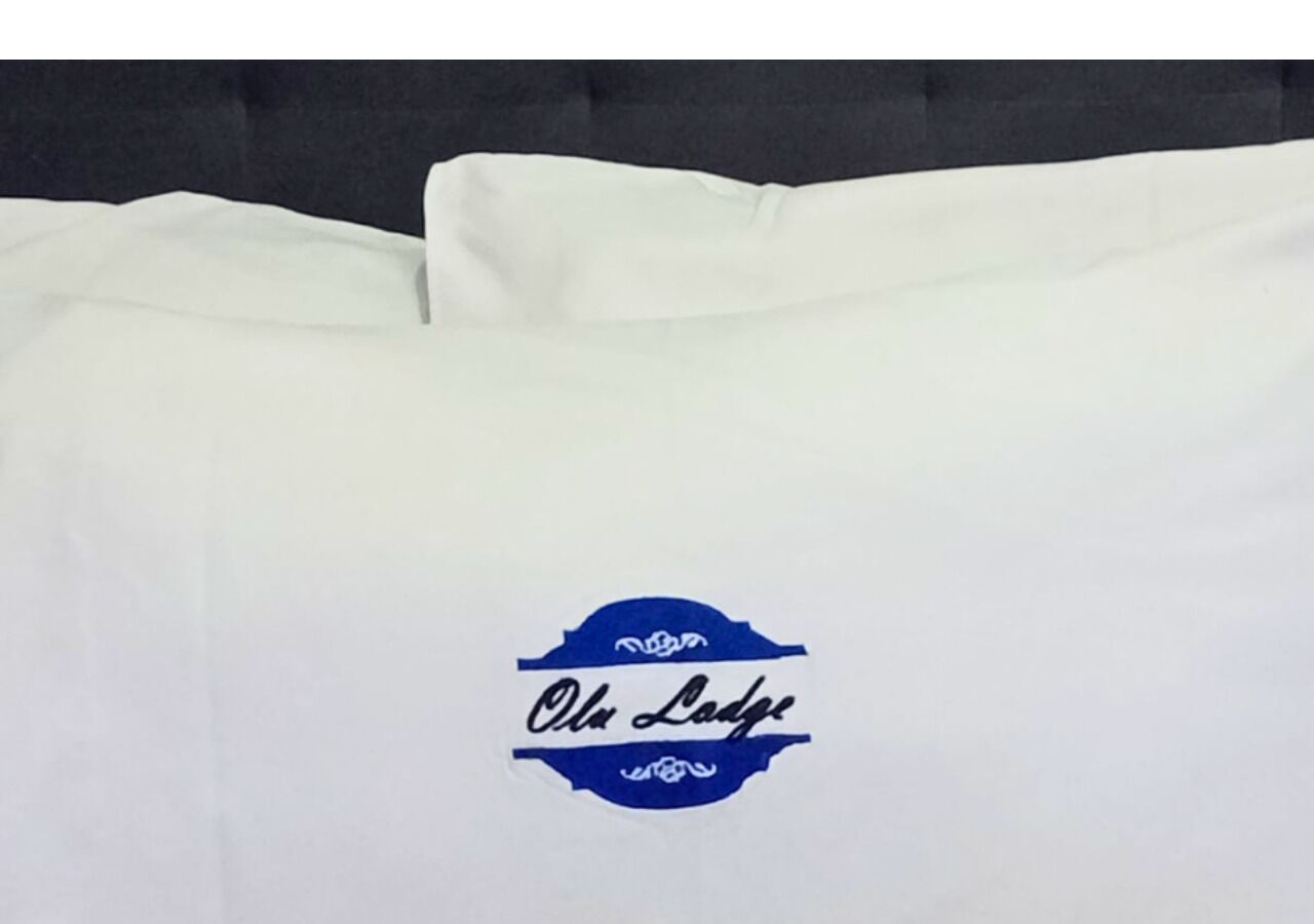 A white pillow with a blue logo and text.