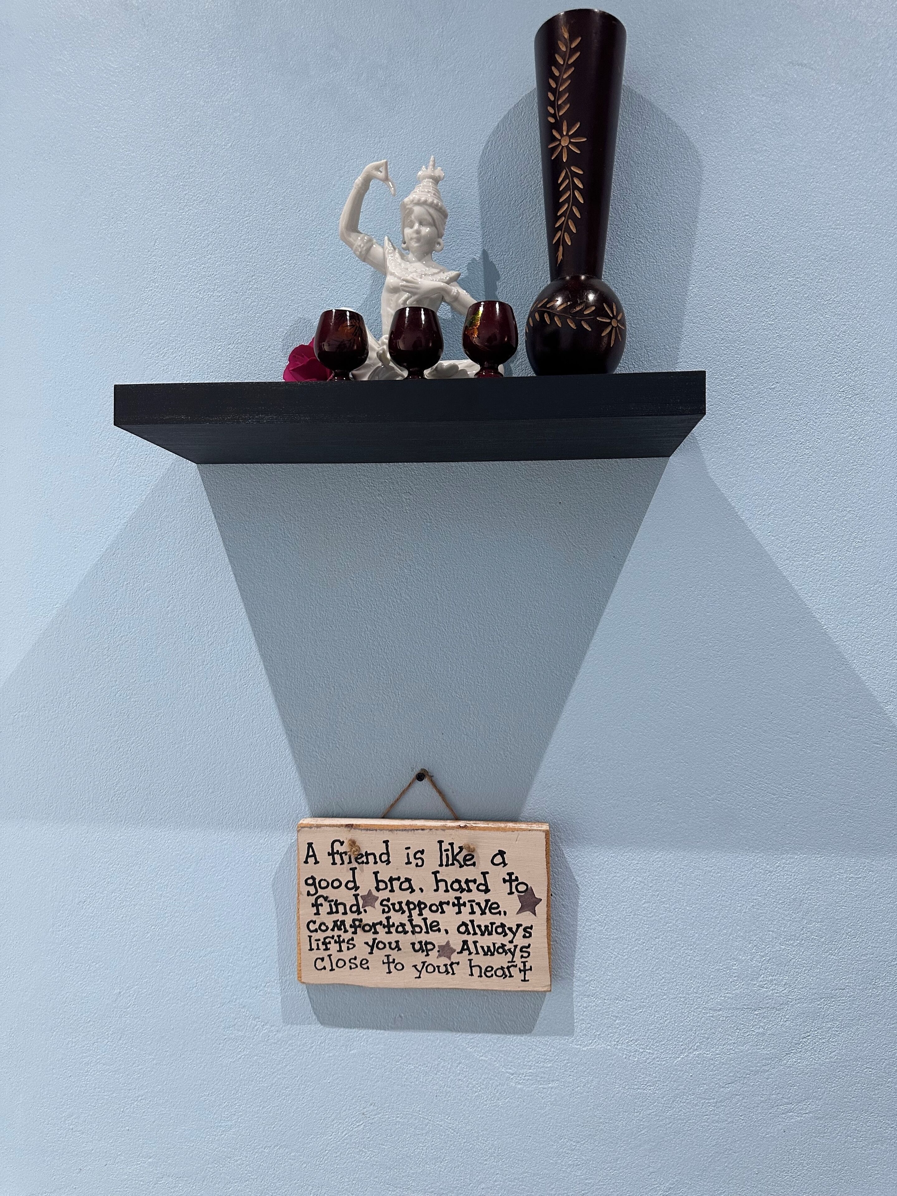 A shelf with decorative items and a sign.