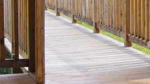 A wooden boardwalk leading to a grassy area with a building in the background. - Private Oasis - Portland’s Coastal Gated Hideaway (Fair Prospect)