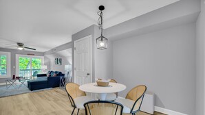 Un salon moderne comprenant un coin repas, un ventilateur de plafond et une vue sur l’extérieur.
