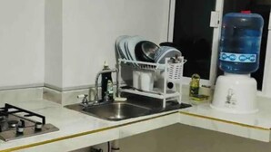 A kitchen with a gas stove, sink, dish rack, and a water dispenser. - Cozy house near the beach (Mazatlan)