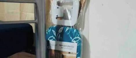 Una habitación con una cama nido, un calentador portátil y un objeto embalado en el suelo.
