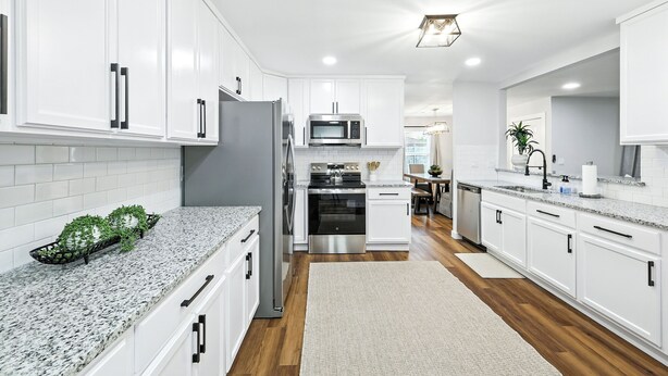 A modern kitchen with white cabinets, stainless steel appliances, and a granite countertop. - Flower Mound Manor - Modern 3BR New Construction (Flower Mound)