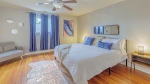 A bedroom with a bed, a ceiling fan, a nightstand, a lamp, and a window with curtains. - 3 King BedRooms Spacious & Serene House, Private Yard and Parking in Chattanooga (Chattanooga)