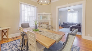 A dining area with a wooden table, chairs, a chandelier, and a large mirror above the table. - 3 King BedRooms Spacious & Serene House, Private Yard and Parking in Chattanooga (Chattanooga)
