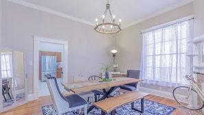 A dining area with a wooden table, benches, and chairs. There is a chandelier above the table. - 3 King BedRooms Spacious & Serene House, Private Yard and Parking in Chattanooga (Chattanooga)