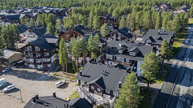 A residential area with multiple houses, a parking lot, and a road. - Jukola Juhani by Aavalevi Holidays (Levi)