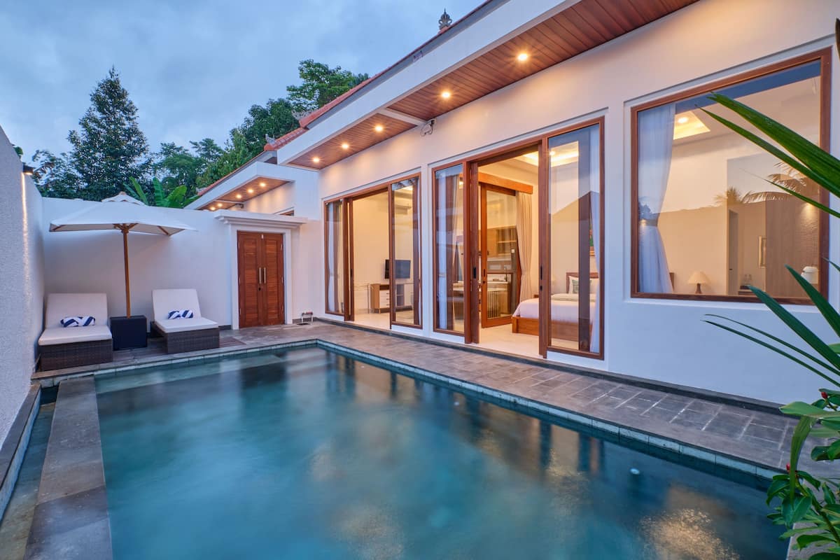 A modern house with a swimming pool, large windows, and a well-lit interior.