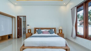 Un dormitorio con una cama grande, cabecera de madera, lámparas de noche y vistas al exterior.
