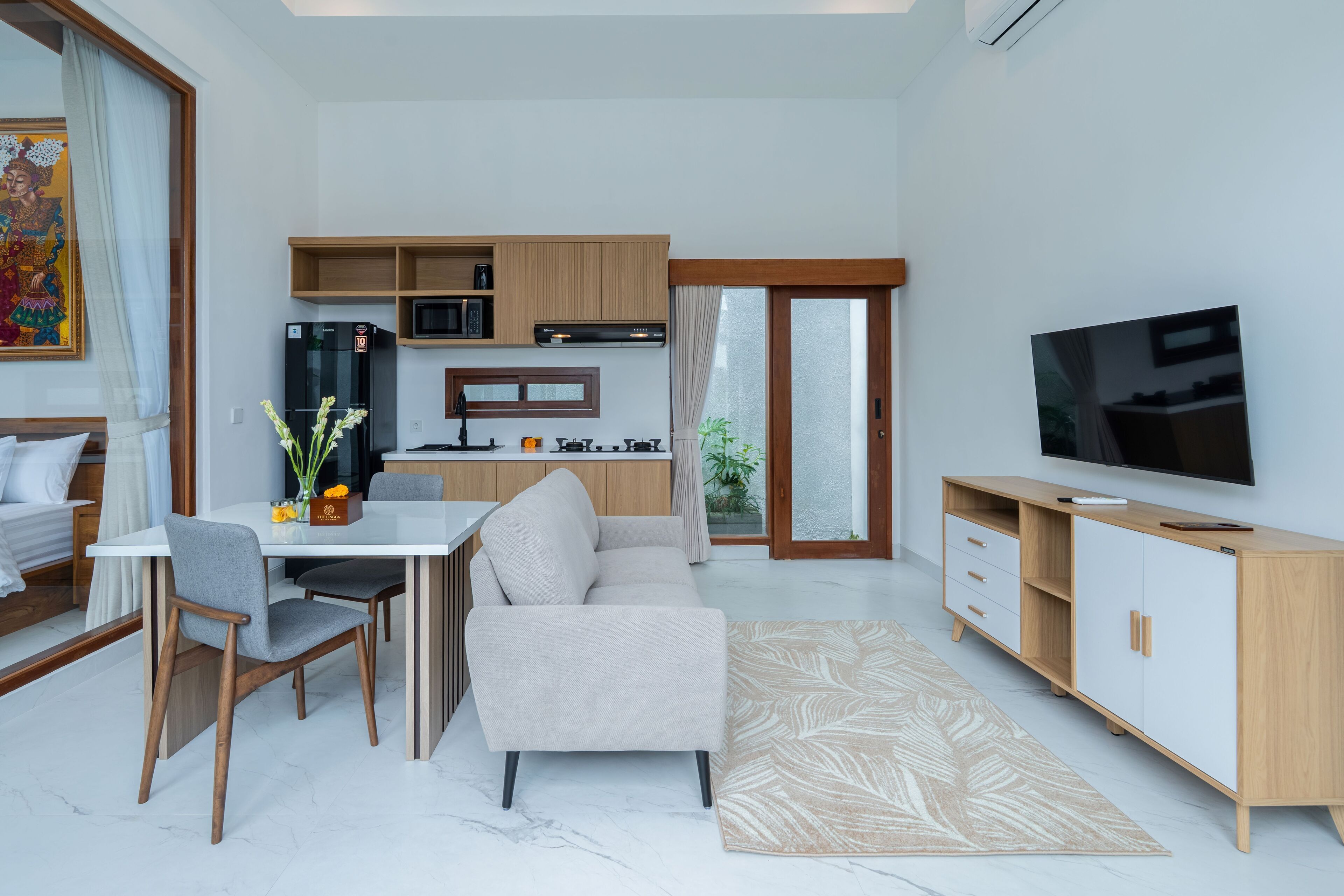 A modern living room with a sofa, dining table, and TV.