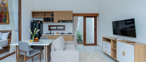 A modern living room with a sofa, dining table, and TV.