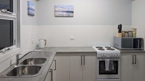 A modern kitchen with stainless steel appliances, a double sink, and a stove.