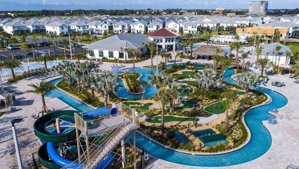 A resort with multiple buildings, a large pool area with slides, and a golf course. - Condo 2bd/2bh 15 min from parks Storey Lake (Kissimmee)
