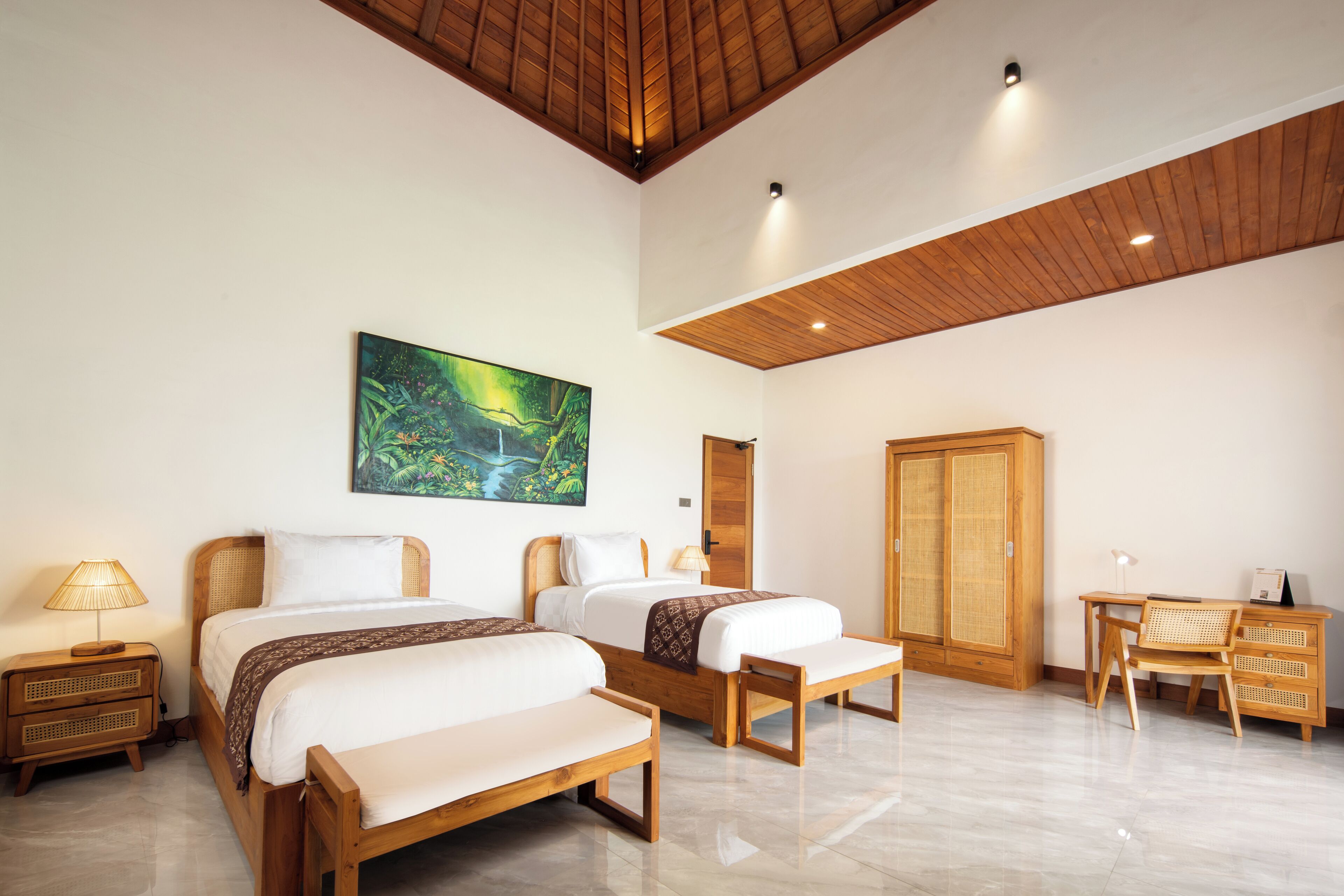A spacious room with two beds, a desk, and a wardrobe.