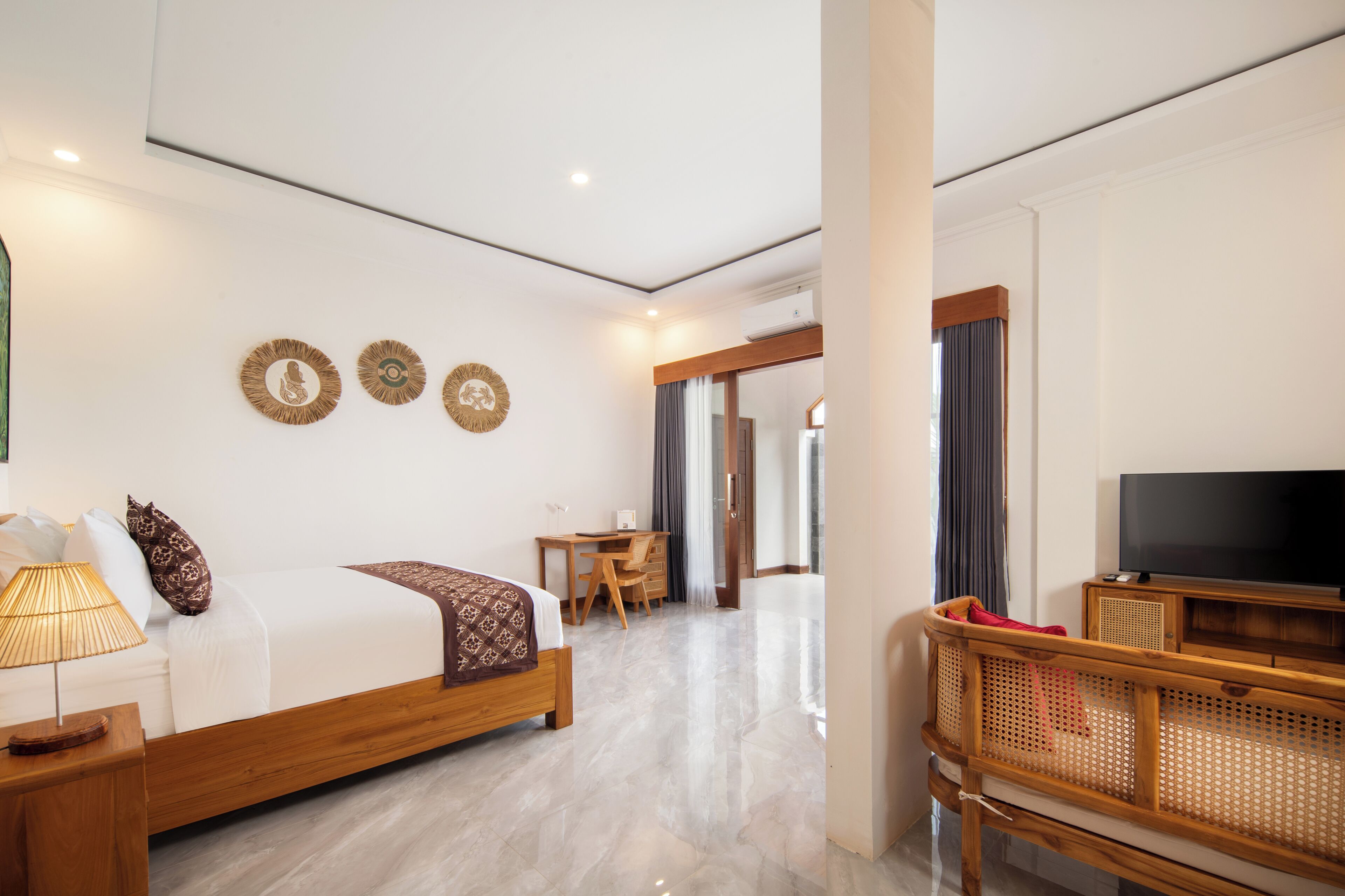 Una habitación de hotel con cama, escritorio, televisor y zona de estar.