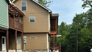 A two-story building with a balcony on the second floor, a gravel driveway, and a stone border around the driveway. - Quiet, relaxing, Guest House with large porch on Cagle Mountain in Dunlap, Tn. (Dunlap)