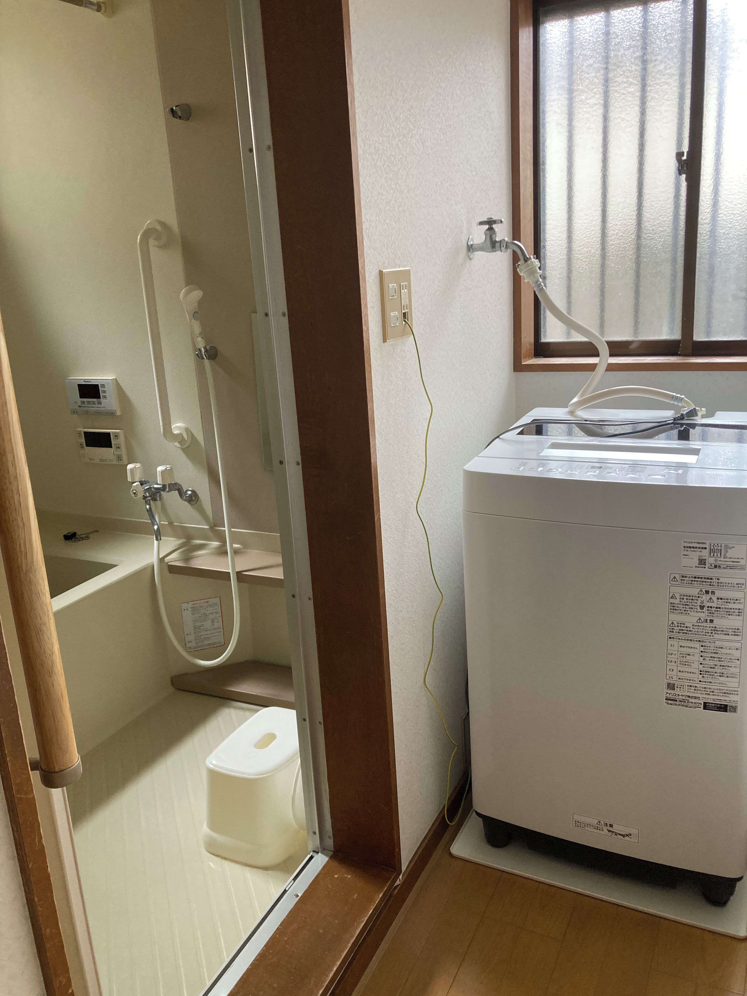 A bathroom with a toilet, a shower, and a water heater.