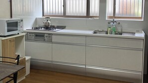 Eine moderne Küche mit weißen Schränken, einer Mikrowelle, einem Herd und einem Spülbecken.