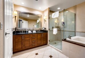 A modern bathroom with a large mirror, a glass shower enclosure, and a separate bathtub.