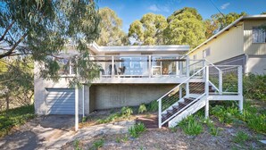 A modern two-story house with a garage, a staircase, and a balcony. - Coningham Beach House (Coningham)