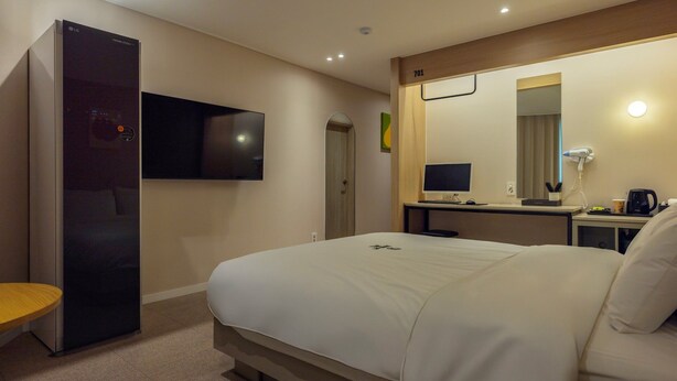 A hotel room with a bed, a desk with a computer, a TV, and a mirror. - Browndot hotel Jeonju Junghwasan (Jeonju)